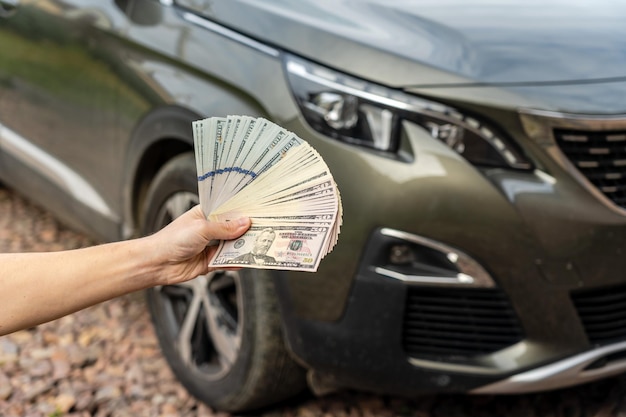 Persoon met geld in de hand staat voor auto Verzekeringslening en autoconcept kopen