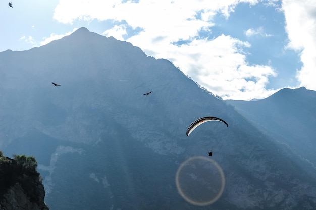 Persoon paragliding op bergtop tegen de lucht