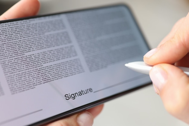 Persoon zet handtekening met stylus op contractscherm van smartphone