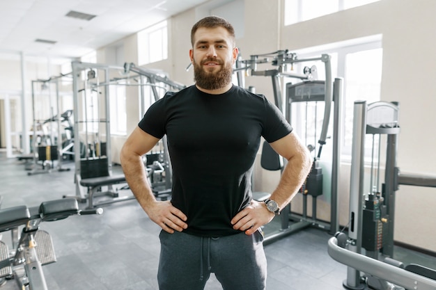 Persoonlijke fitnesstrainer in sportschool camera kijken