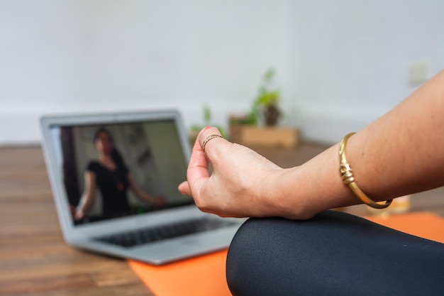 Perspectief van de hand van een vrouw die yoga beoefent voor de laptop