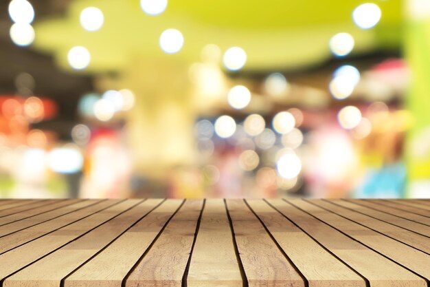 Perspective empty wooden table over blurred shopping mall background