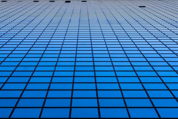 Perspective of the facade of a modern skyscraper with large reflected surfaces