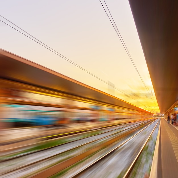 モーションブラーの日没時の鉄道駅のプラットフォームの視点-抽象的な背景