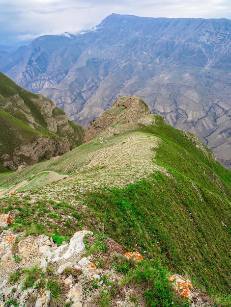 Perspective of rocky ledge. Edge of the cliff, a dangerous gorge. Beautiful landscape on the rainy high plateau. Vertical view.