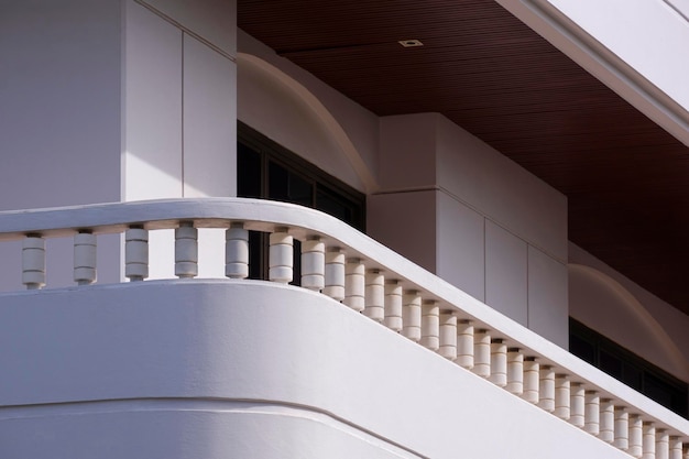 Perspective side view of banister on balcony of white modern house building