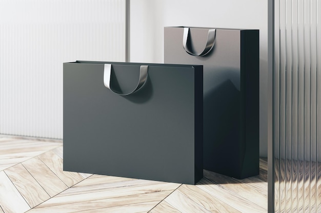 Perspective view on blank black paper shopping bags with place for your brand name or text on light wooden parquet floor near partition and white wall background close up 3D rendering mockup