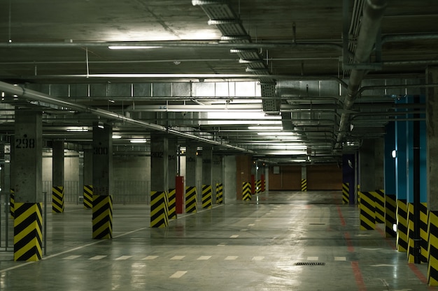 Perspective view of interior of empty parking area with rows of\
columns and marks and no cars around