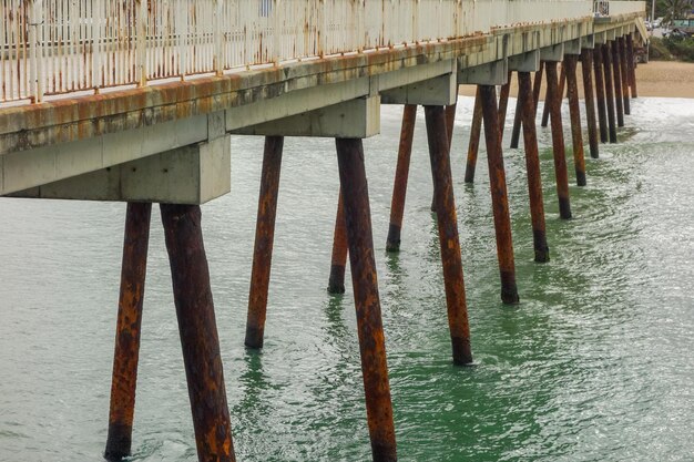 Perspective view of an old wooden pier at beach edge