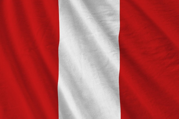 Peru flag with big folds waving close up under the studio light indoors The official symbols and colors in banner