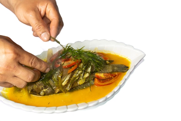 Peruaans eten Sudado de Cabrilla Handen versieren het bord Vis gekookt full body