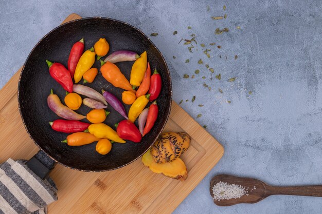 Peruaanse chilipepers van verschillende kleuren op grijze tafel