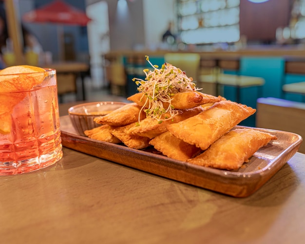 Peruvian tequeños and cocktail in restaurant.