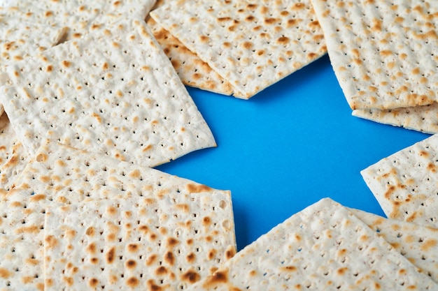 Pesach viering concept Blue Star of David gemaakt van matzah witte en gele rozen kippah en walnoot op bluebackground Traditioneel ritueel Joods Pascha eten Pesach Joodse feestdag Mock up