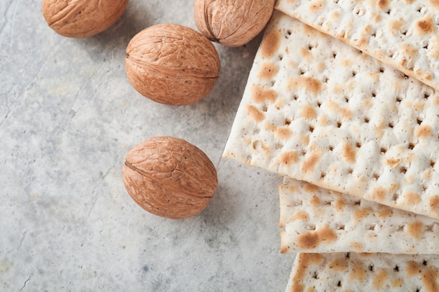 Pesach viering concept Matzah rood koosjer en walnoot Traditioneel ritueel Joods brood matzah kippah en tallit op oude betonnen achtergrond Pesach voedsel Pesach Joodse feestdag