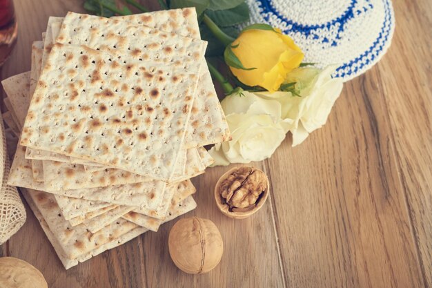 Pesach viering concept Matzah rood koosjer en walnoot Traditioneel ritueel Joods brood matzah kippah en tallit op oude houten achtergrond Pesach voedsel Pesach Joodse feestdag Getinte afbeelding