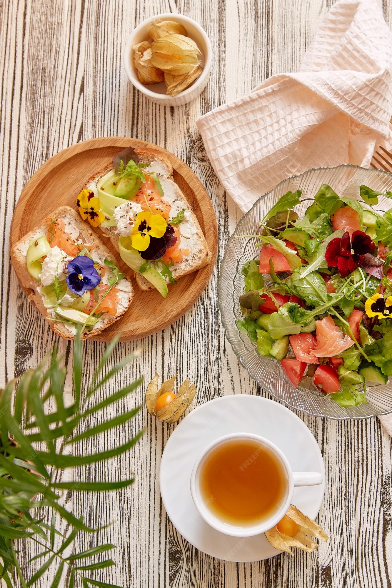 Premium Photo | Pescetarian food toasts and salad with smoked salmon cottage cheese edible flowers vegetables and greens cup of tea aesthetic autumn lunch time