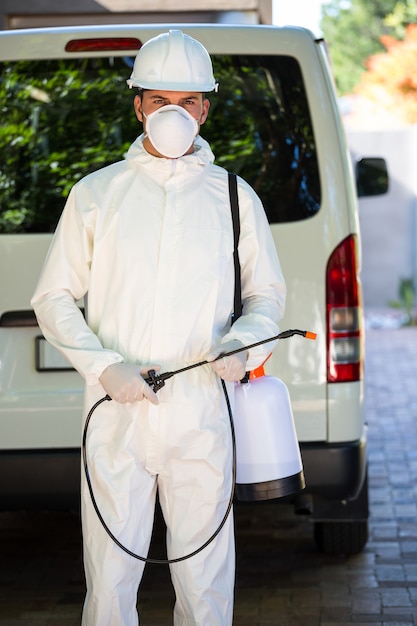 Pest control man standing behind a van