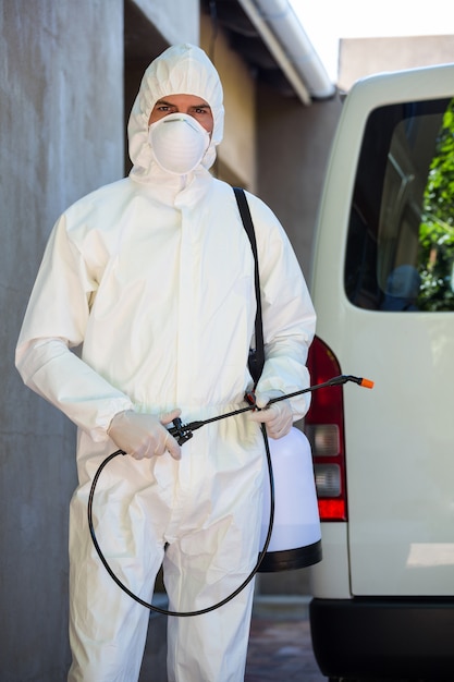 Pest control man standing behind a van