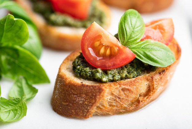 Pesto bruschetta with cherry tomatoes and basil