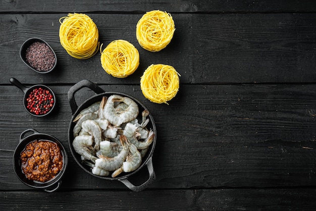 Pesto garnalen pasta ingrediënten ingesteld, op zwarte houten tafel, bovenaanzicht plat lag, met kopie ruimte