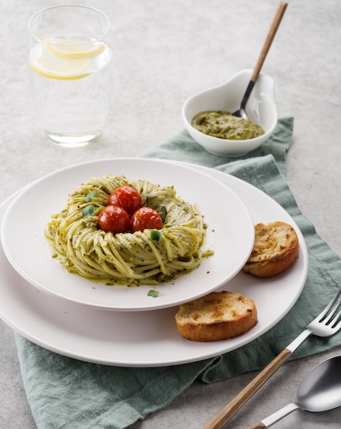 Pesto pasta with cherry tomatoes on a white plate. Italian Cuisine