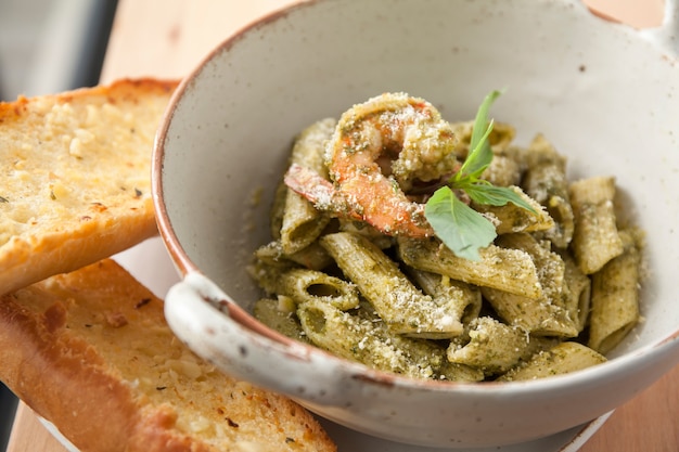 Pesto penne pasta with shrimp and garlic bread