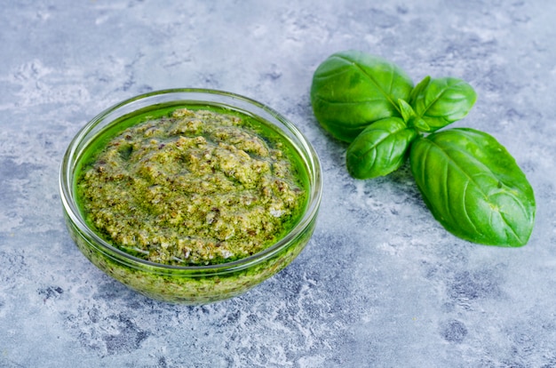 Photo pesto sauce and fresh green basil leaves.