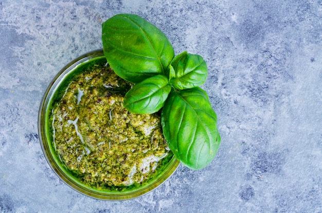 Pesto sauce and fresh green basil leaves. 