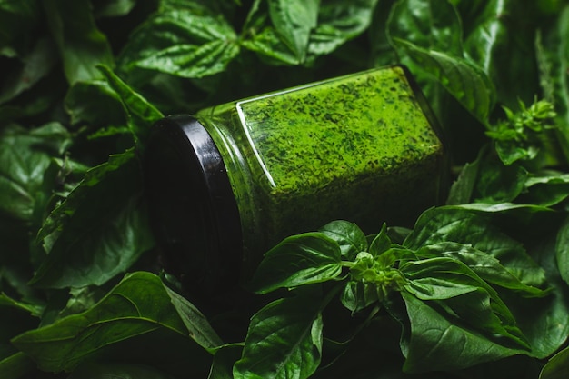 Pesto sauce in a glass jar green basil leaves