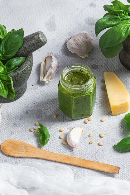 Pesto sauce in a glass jar on the table Basil