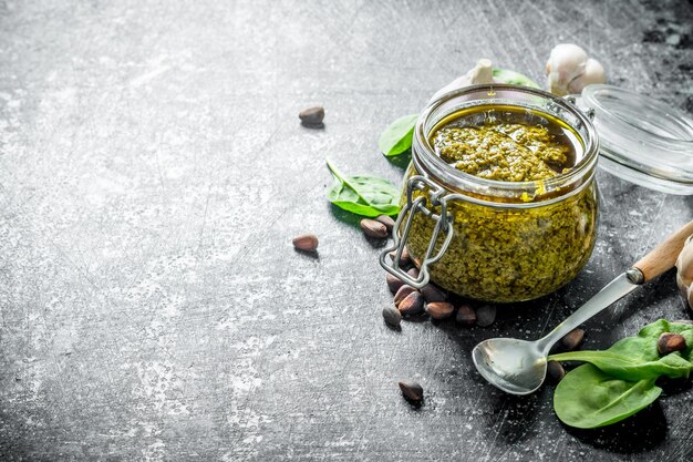 Pesto sauce in a glass jar with garlic and herbs