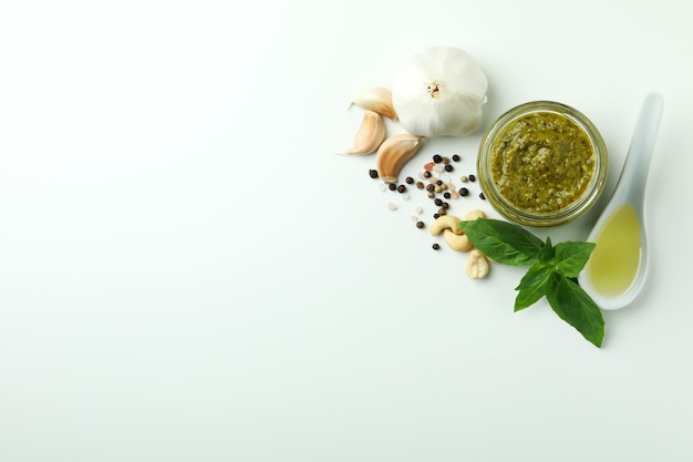 Pesto sauce and ingredients on white background