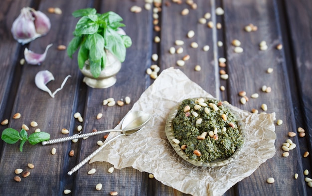 Pesto sauce and ingredients on wooden background