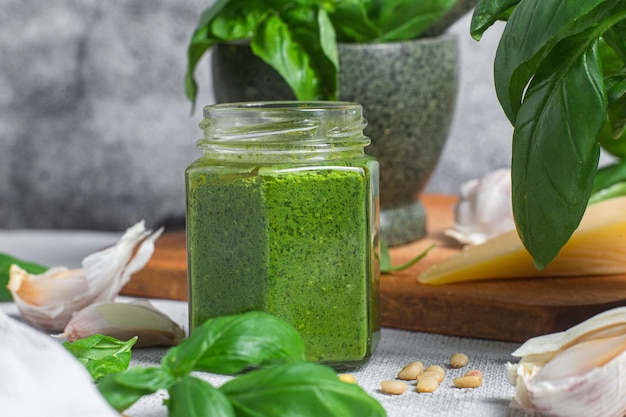 Pestosaus in een glazen pot op tafel Basilicum