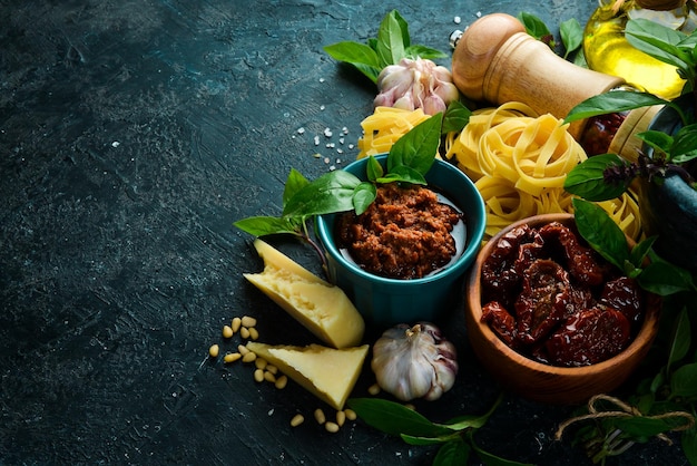 Pestosaus met zongedroogde tomaten in een kom Traditionele Italiaanse saus Op een betonnen ondergrond