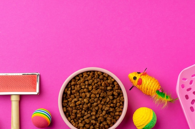 Foto ciotola per animali domestici con cibo secco e giocattoli su sfondo colorato