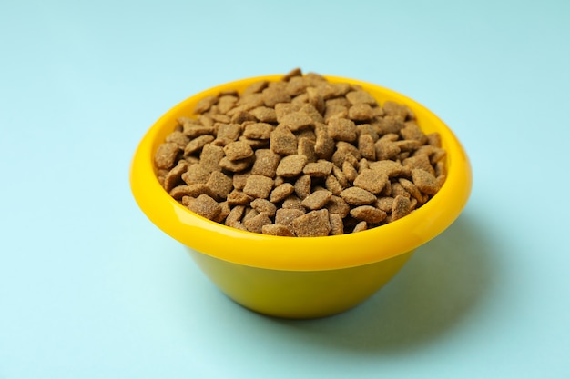 Pet bowl with feed on blue