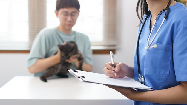 Pet care concept Female veterinary is writing prescription on clipboard after examining health cat