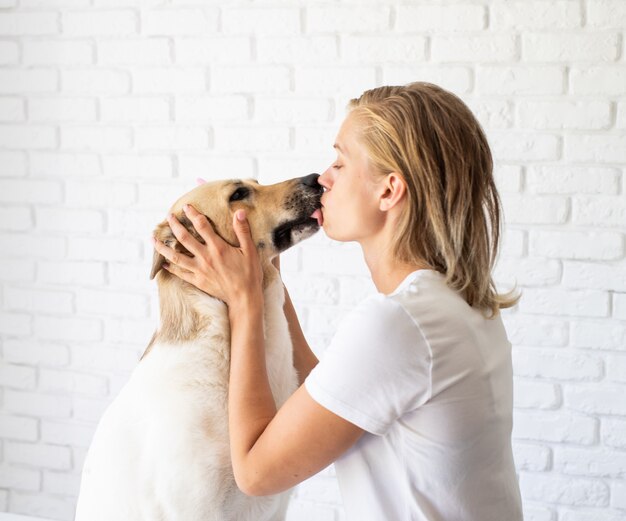 ペットケアのコンセプト。犬の歯を磨く若い女性