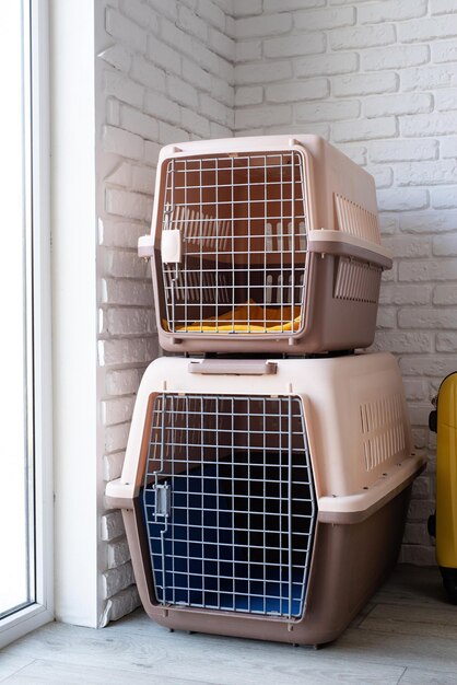 Pet corner plastic pet carriers or pet cages with yellow travel case on the floor at home