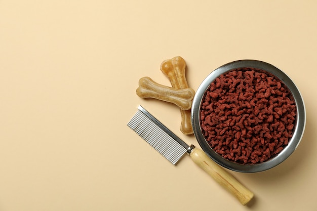 Pet feed and hair brush on beige background