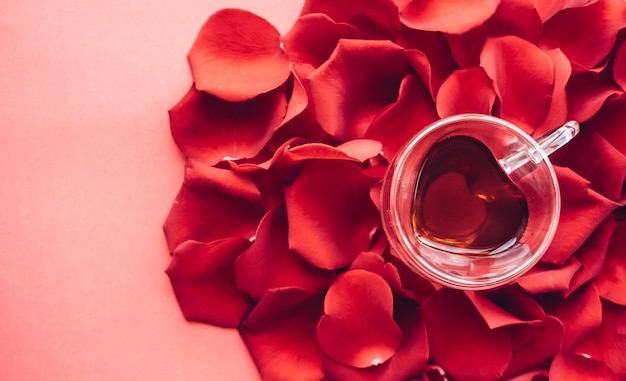 Photo petals of red roses and tea happy valentines day greeting background