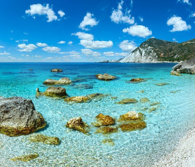 Petani Beach zomer weergave met grote stenen in water en diepblauwe bewolkte hemel Kefalonia, Griekenland.