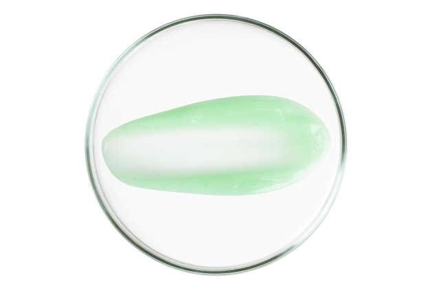 Petri dish isolated on empty background A smear of green gel serum in a Petri dish