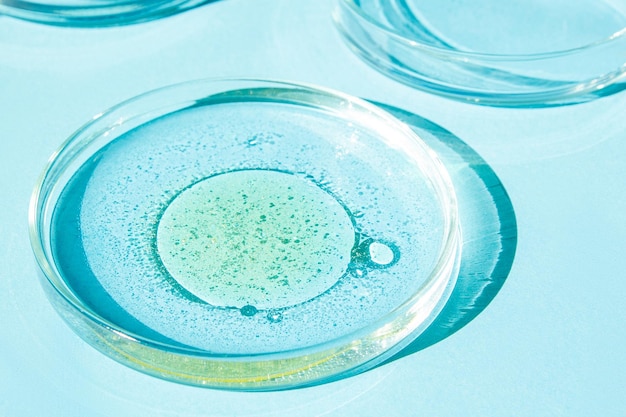 シャーレ シャーレ 液体 化学元素 オイル 化粧品 ゲル 水 分子 ウイルス クローズアップ 青の背景に