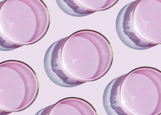 Petri dish with liquid on plain pink background