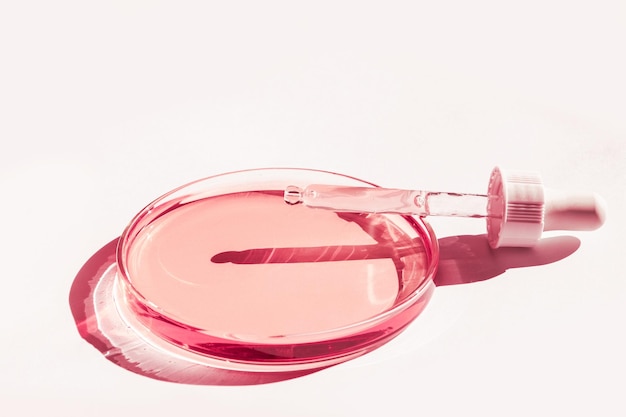 Petri dish With pink liquid With solution Cosmetic pipette On a white background