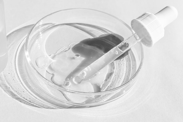 petri dish with transparent gel the pipette lies cosmetic dispenser on a white background