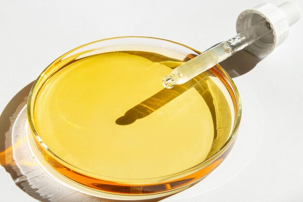 Petri dish With yellow liquid With solution Cosmetic pipette On a white background